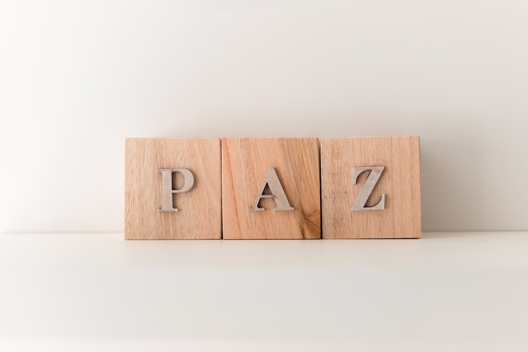 Three wooden blocks with silver letters spelling PAZ on white.